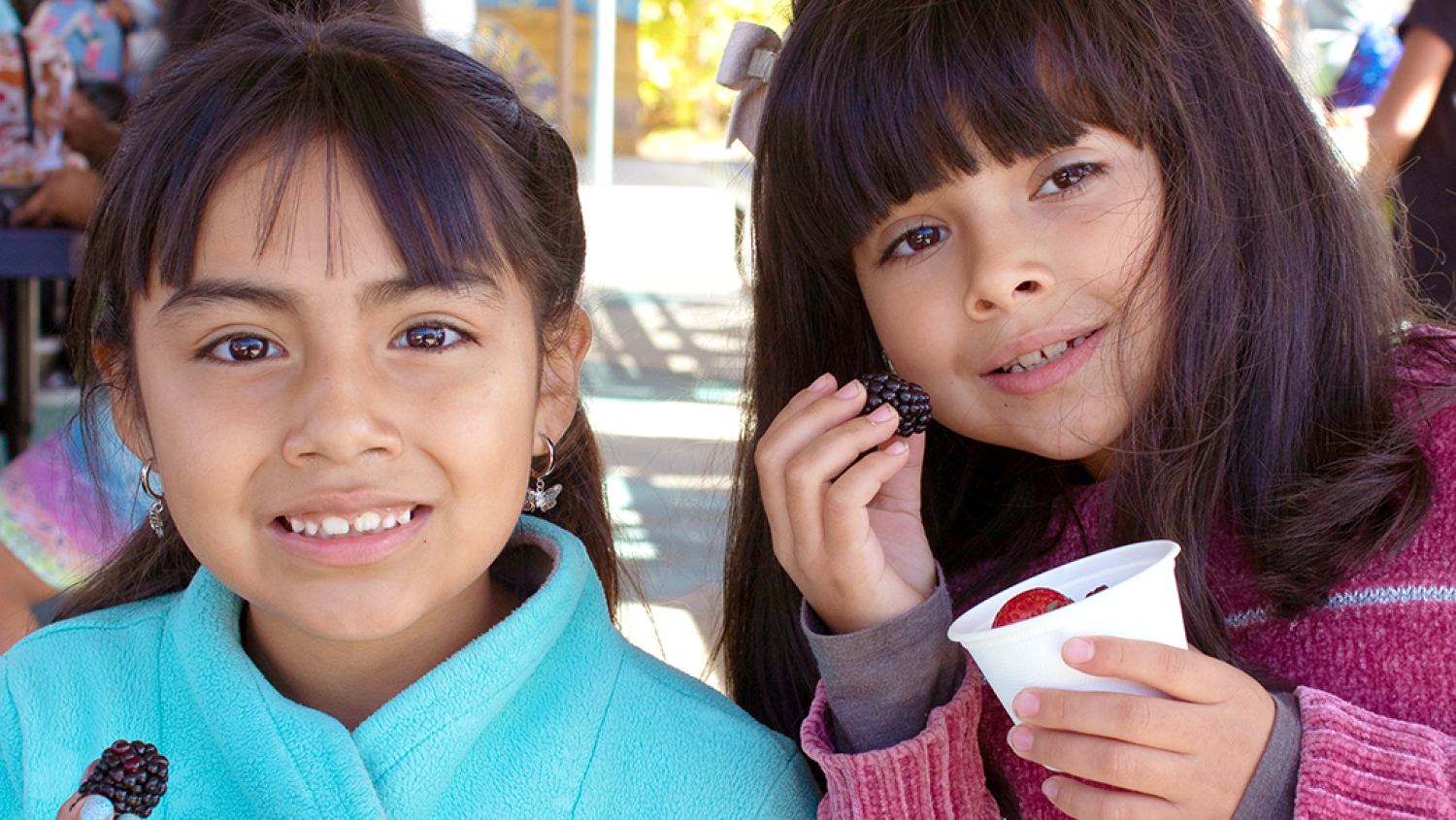 two students taste test berries